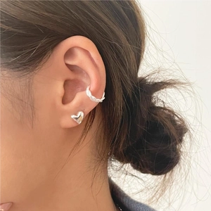 Close-up of minimalist S925 silver heart stud and twisted ear cuff on ear