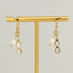 Golden geometric earrings with irregular pearls and white shell charms on T-bar stand