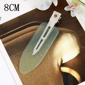 Detail showing 8cm light green resin hair clip with gold glitter and metal spring