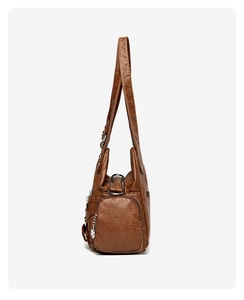 Side view of brown soft faux leather tote bag showing metal zipper and hardware details