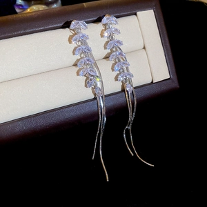 Detail of silver drop earrings with marquise zircon wheat ear patterns and long tassels