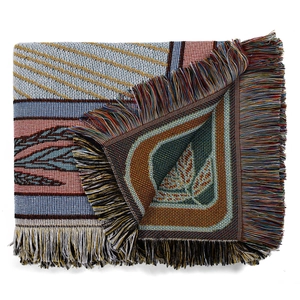 Macro detail of Bohemian woven outdoor blanket featuring cotton fringe and leaf patterns