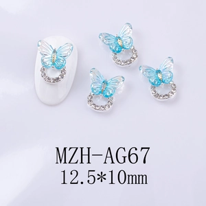 Detail of blue resin butterfly nail charm with silver base and tiny white rhinestones