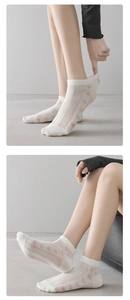 Detail of white mesh ankle socks featuring pink floral patterns and elastic lace cuffs
