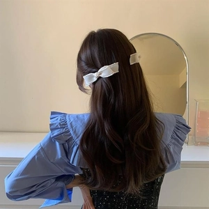 Rückansicht eines Modells mit einer großen weißen Stoff-Schleife Haarspange im Prinzessin-Stil