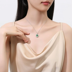 Elegant S925 silver necklace with emerald pendant and diamonds worn by a model