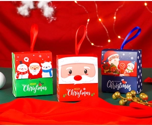 Detail of Christmas candy gift boxes with silk handles and festive Santa Claus patterns
