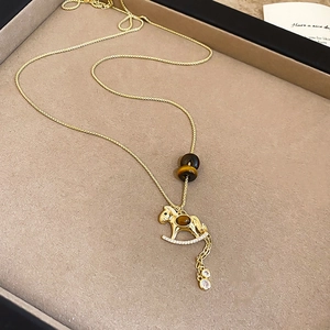 Detail of a rocking horse necklace with tiger eye beads and white zircon micro-inlays