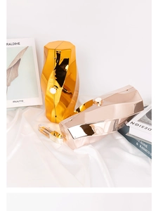 Detail of geometric metallic evening clutch bags in gold and rose gold on silk