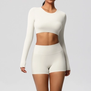 Detail view of white yoga set featuring long sleeve cropped top and high waist sports shorts