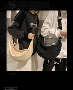 Detail showing beige and black nylon crescent crossbody bags with wide shoulder straps