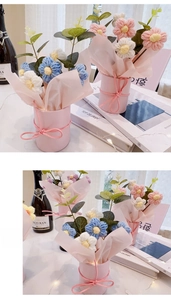 Detail of hand-knitted flower bouquet in a pink bucket with decorative bow tie
