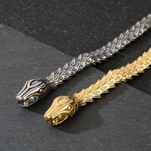 Macro shot of gold and silver snake necklaces showing intricate scale textures and heads