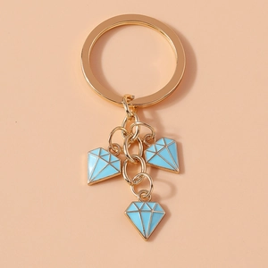 Detailed close-up of light blue enamel diamond charms on a golden alloy keychain pendant
