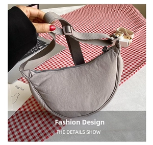 Detailed view of grey nylon crescent crossbody bag with adjustable strap and zip closure