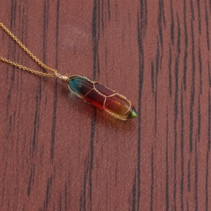 Close-up of a gradient crystal hexagonal column necklace with gold wire wrapping details