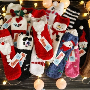 Thick coral fleece Christmas socks set with festive holiday patterns on wooden background