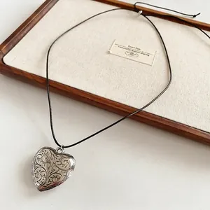 Vintage heart pendant necklace with floral engraving on a black wax cord for women