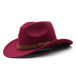 Detail of burgundy wool fedora featuring a dark brown leather band and gold metal buckle