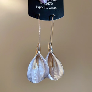 Vue détaillée de boucles d'oreilles pendantes en forme de lys au fini nacré