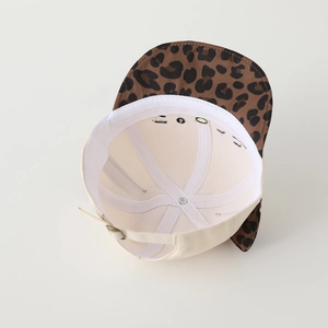 Detail view of cotton baseball cap interior featuring adjustable metal strap and leopard print