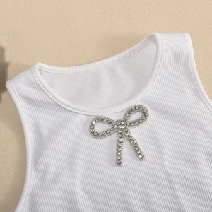 Close-up of white ribbed knit crop top featuring a sparkling rhinestone bow detail