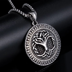 Macro view of silver Tree of Life pendant with vintage sunray pattern and box chain