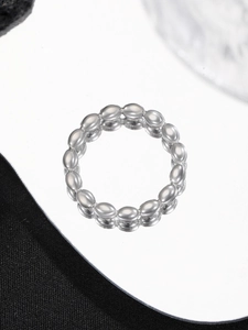 Detailed view of a beaded ring with milky white oval stones on a reflective surface