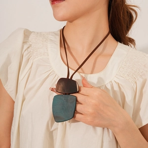 Detail of vintage irregular resin square pendant with brown and turquoise resin on leather cord