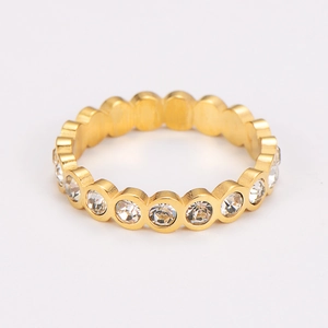 Close-up of a slim gold stainless steel eternity ring with shimmering round crystals