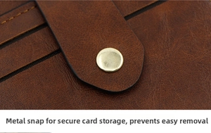 Close-up of brown faux leather card holder with gold snap button and stitched detail