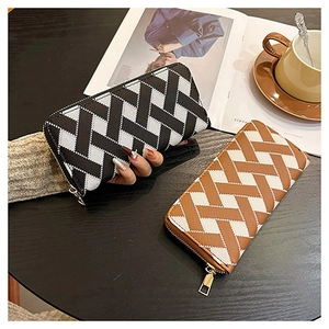 Close-up of dual-tone long zip wallets with geometric patterns on a wooden table