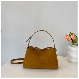 Detail view of camel suede handbag with silver hardware and tulip floral decor