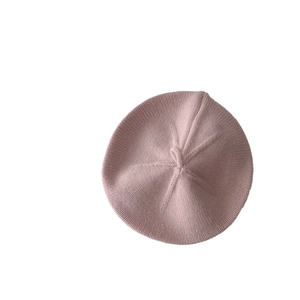 Classic knitted pink baby beret with a top loop shown in a clean minimalist studio shot
