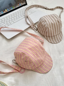 Retro striped baseball cap crossbody bags in pink and white canvas on a desk
