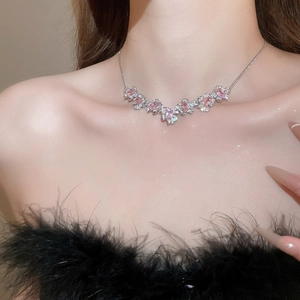 Close-up of elegant silver necklace with pink zircon flower pendants on model neck