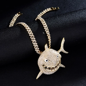 Fashionable gold Cuban chain necklace featuring a crystal-encrusted shark pendant with white eyes