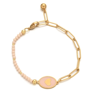 Detail of beaded bracelet with pink matte stones and gold heart charm on paperclip chain