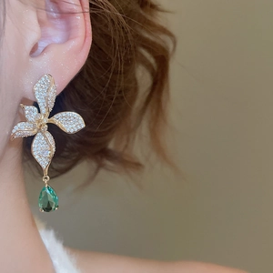 Close-up of luxury 18k gold plated flower earrings with green waterdrop zirconia on model