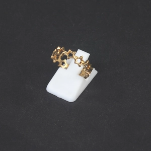 Golden hollow star-shaped ring displayed on a white stand with a minimalist design