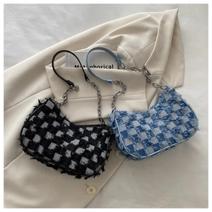 Detail of plaid denim shoulder bags with frayed fringe textures and metal chains