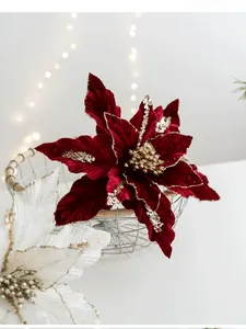 Dettaglio di poinsettia in velluto con petali glitterati dorati in un cesto metallico