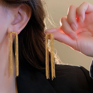 Detailed view of long gold multi-strand beaded chain tassel earrings with metallic shine