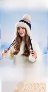 Detail view of winter knitted earflap hat with soft plush lining and pom-poms for warmth