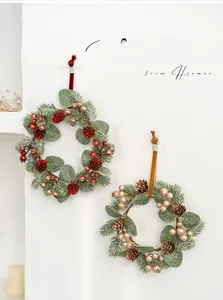 Detail von roten und champagnerfarbenen Adventskränzen mit Tannenzapfen und Samtbändern
