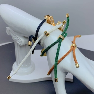 Close-up of adjustable braided cord bracelets with St. Jude micro-pave charms