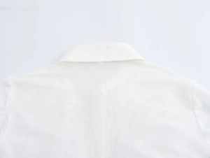 Dettaglio del colletto a revers in rete bianca su un'elegante camicia francese a maniche lunghe