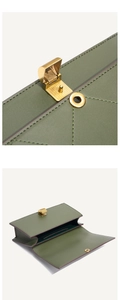 Macro view of dark green leather bag with brass lock and gusseted interior compartments
