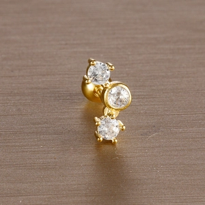 Macro shot of gold stainless steel stud earrings featuring three sparkling zircon stones