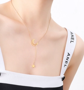 Detail of 18K gold-plated Y-shaped necklace featuring celestial moon and star pendants
